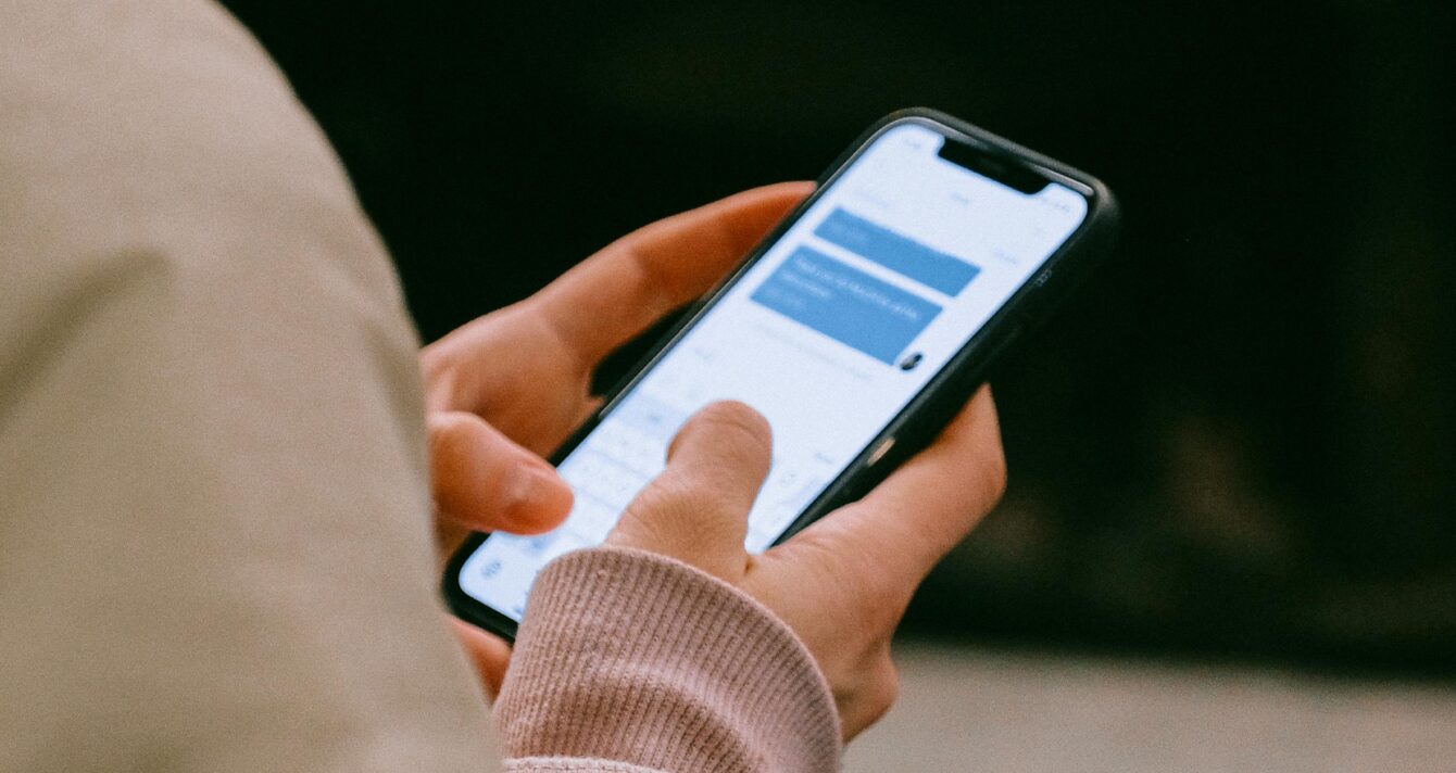 A person using a smartphone for texting, focusing on their hands and device screen.